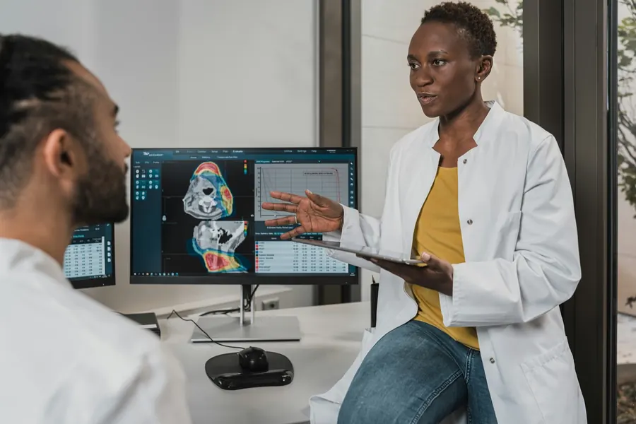 Une médecin explique une image médicale sur l’écran de son cabinet